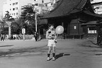 浅草で風船を持つ子供時代の太一郎氏